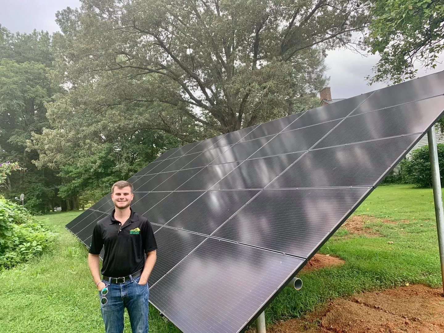 Earth Right Mid Atlantic employee standing in front of ground mounted solar panels