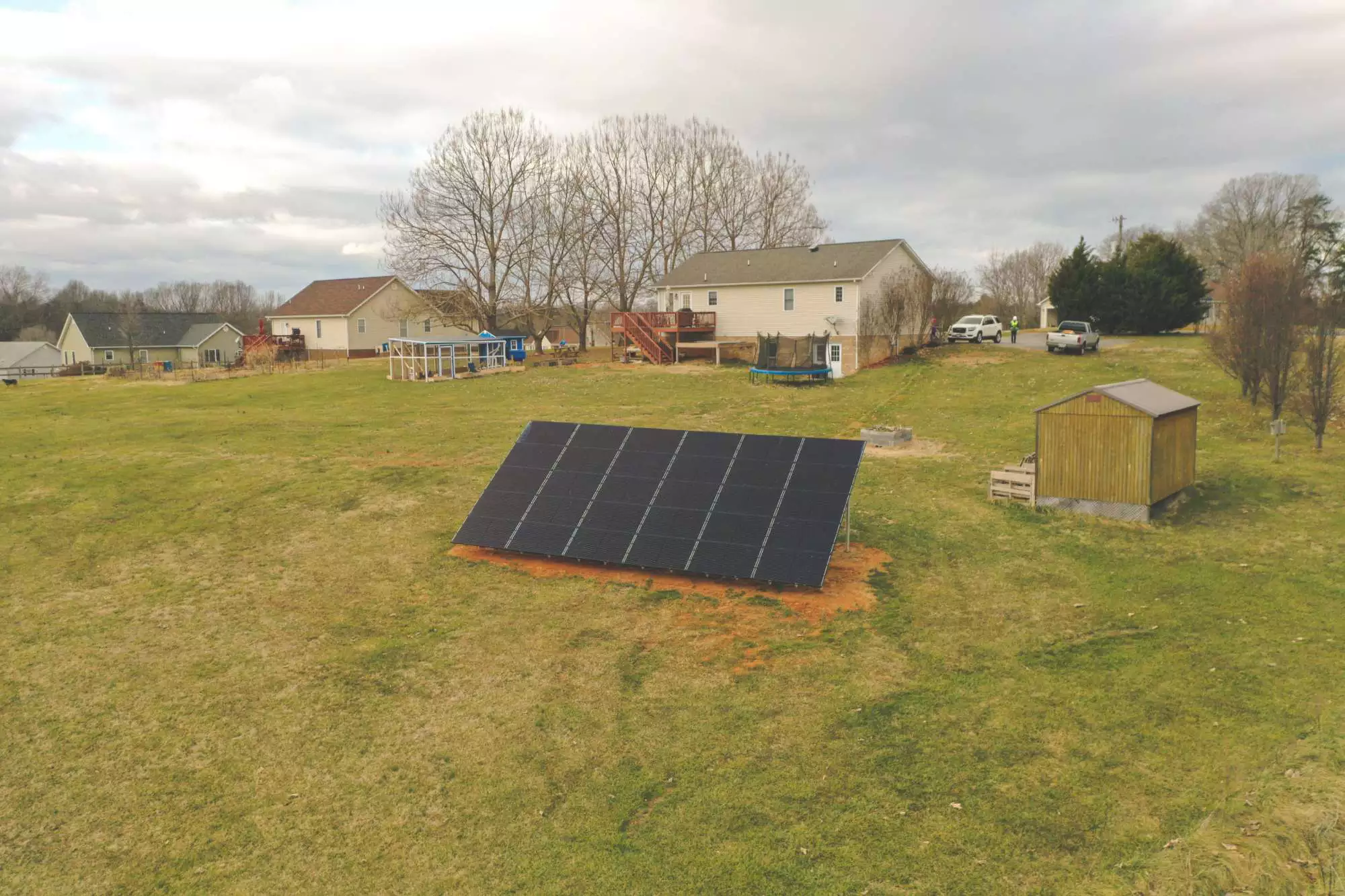 Ground mounted solar panels with home in the background