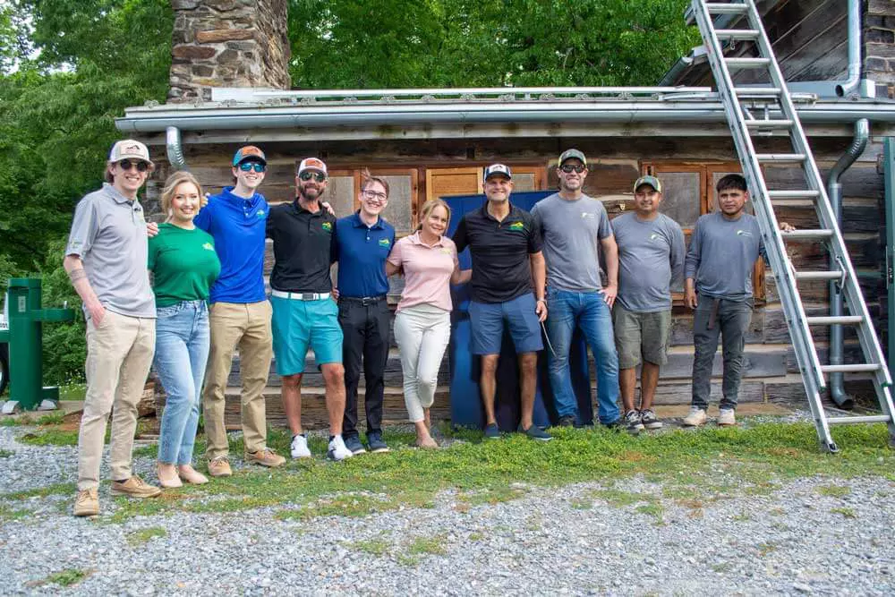 Earth-Right Mid Atlantic team standing in front of Ivy Creek park cabin with solar on the roof