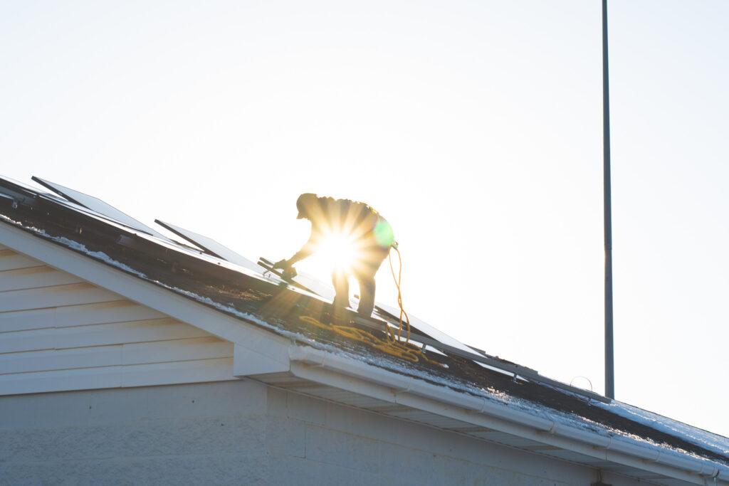 a solar installer completing solar panel repairs